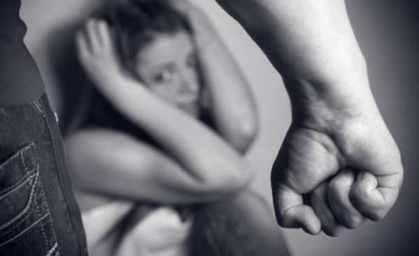 Woman cowering on floor after being physically or psychologically abused