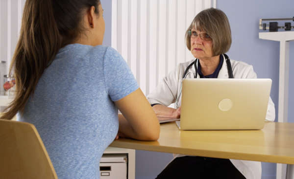 Latino patient with doctor at table during consultation