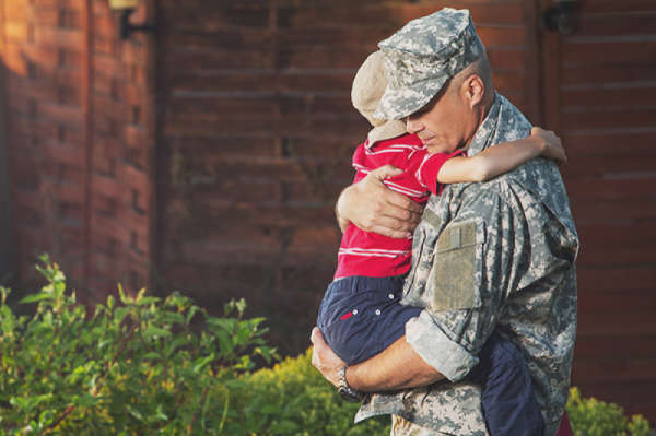 uniformed soldier holding his young son